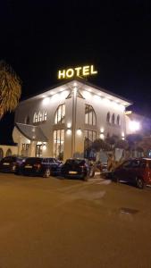 un hôtel avec des voitures garées dans un parking la nuit dans l'établissement La Rustica Hotel, à Capo Rizzuto