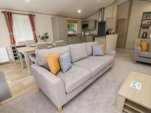 Una sala de estar con un sofá y una cocina. en Barney's Retreat, en Carnforth