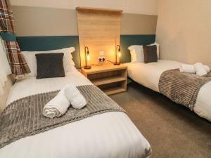 2 camas en una habitación de hotel con toallas blancas en Barney's Retreat, en Carnforth