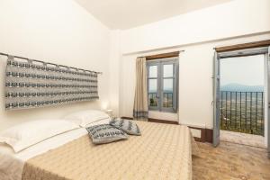 - une chambre avec un lit et une grande fenêtre dans l'établissement Antico Forno Baunei, à Baunei