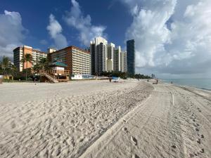 a sandy beach with buildings in the background at Beachfront condo in Miami! in Sunny Isles Beach