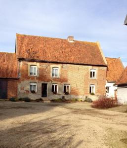 an old brick house with a red roof at Au repos du roi in Maisoncelle