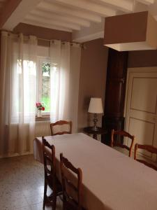 ein Esszimmer mit einem Tisch, Stühlen und einem Fenster in der Unterkunft Au repos du roi in Maisoncelle