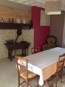 a dining room with a white table and chairs at Au repos du roi in Maisoncelle