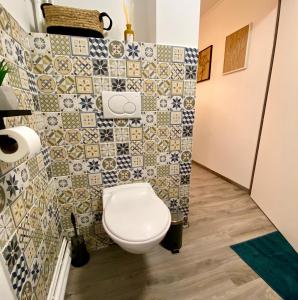 łazienka z toaletą i płytkami na ścianie w obiekcie Studio Capucine - Centre ville - Jolie vue - Cosy w mieście Eu