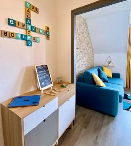 Pokój z niebieską kanapą i biurkiem w obiekcie Studio Capucine - Centre ville - Jolie vue - Cosy w mieście Eu