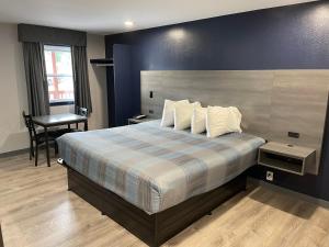 1 dormitorio con 1 cama grande y escritorio en Golden Hill Inn-Danbury, en Danbury