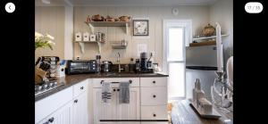 a kitchen with white cabinets and a refrigerator at Your Most Romantic and Peaceful Getaway in El Sobrante