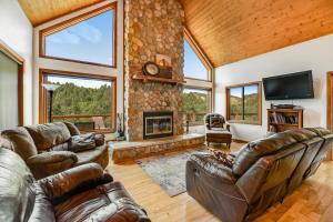 a living room with leather furniture and a stone fireplace at Aces and Eights Lodge in Sturgis