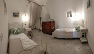 a bedroom with two beds and a dresser in it at Villa Sportelli - Antica Dimora in Selva di Fasano
