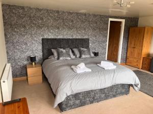 a bedroom with a large bed with towels on it at The Lamb of Rhos in Llandysul