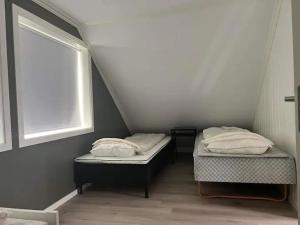 2 camas individuales en una habitación con ventana en Lekkert gjestehus med gratis parkering på stedet., en Levanger