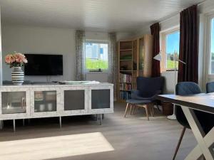 a living room with a television and blue chairs at Lekkert gjestehus med gratis parkering på stedet. in Levanger