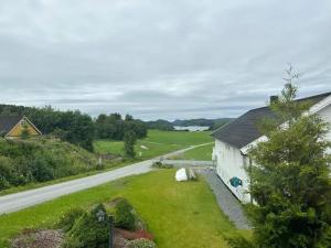 ein weißes Gebäude mit einem Hof neben einer Straße in der Unterkunft Lekkert gjestehus med gratis parkering på stedet. in Levanger