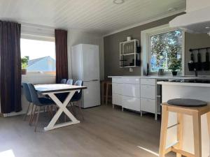 cocina con mesa y sillas en Lekkert gjestehus med gratis parkering på stedet. en Levanger