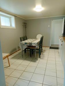 a kitchen and dining room with a table and chairs at FeelHome 2 bedrooms apartment Vidarsveg in Tromsø