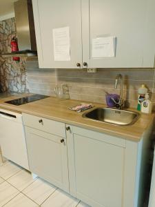 a kitchen with white cabinets and a sink at FeelHome 2 bedrooms apartment Vidarsveg in Tromsø