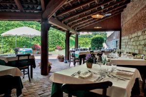 a restaurant with white tables and chairs and a patio at Locanda della Rocca di Camagna in Camagna Monferrato