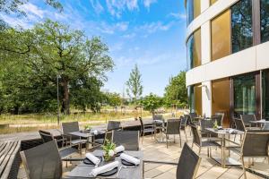 a patio with tables and chairs and a building at Best Western Hotel Airport Frankfurt in Frankfurt/Main
