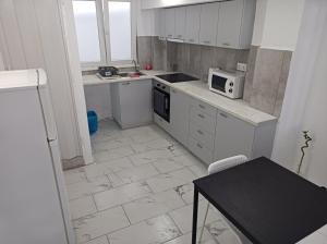 a kitchen with white cabinets and a microwave at Apartment Dipla in Athens
