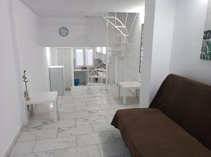 een woonkamer met een bank en een tegelvloer bij Apartment Dipla in Athene