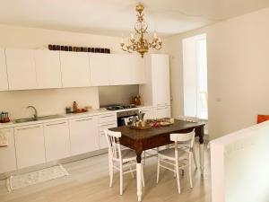 una cucina con tavolo in legno e armadietti bianchi di Jo Sedio Residenza, Bellezza e Relax Monti Lepini a Carpineto Romano