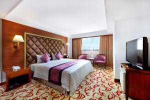 um quarto de hotel com uma cama e uma televisão de ecrã plano em Chyuan Du Spring Resort em Taipei
