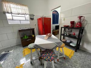 cocina con 2 sillas y nevera roja en Pouso da Meire, en Tiradentes