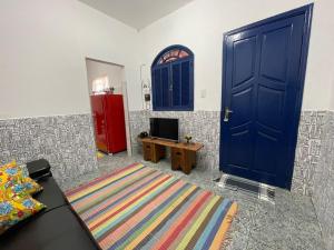 a living room with a blue door and a tv at Pouso da Meire in Tiradentes