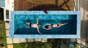 twee mensen zwemmen in een zwembad bij Sky Atins Rooftop in Atins