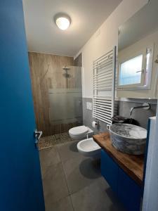 W łazience znajduje się umywalka, toaleta i lustro. w obiekcie Chalet del mare w mieście Cervia