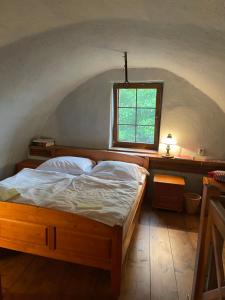 a bedroom with a bed in a room with a window at Vidiecka chalupa 