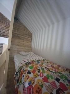 ein Schlafzimmer mit einem weißen Bett mit einer Bettdecke in der Unterkunft Pourquoi pas Au Canard in Jurbise