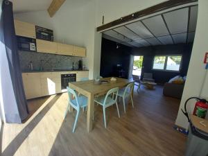 a kitchen and dining room with a table and chairs at Gîtes "Pourquoi pas Au Canard" proche de Pairi Daiza in Jurbise