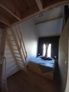 a bedroom with a bed and a window and stairs at Pourquoi pas Au Canard in Jurbise