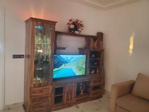 un centro de entretenimiento de madera con TV en la sala de estar en My house 3 en Nador