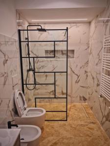 baño con aseo y pared de mármol en Luxury Cecilia via Antonio del Re 9 Tivoli, en Tívoli