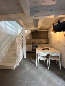 una cocina con una mesa blanca y una escalera en Chalet del mare, en Cervia