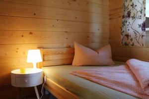 um quarto com uma cama com um candeeiro sobre uma mesa em Domki cało roczne z własnym stawem nad jeziorem em Ryn