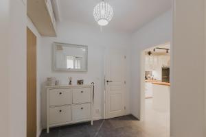 eine weiße Küche mit einer Kommode und einem Spiegel in der Unterkunft Quiet apartment in new city center, NIVY in Nivy