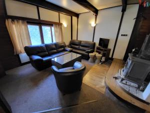 a living room with leather furniture and a tv at Toska rekreační středisko in Prostřední Bečva