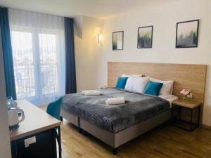 a bedroom with a large bed with blue and white pillows at Willa Domiwera in Polańczyk