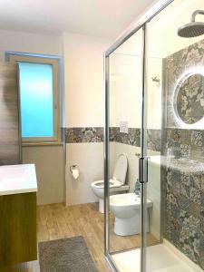 e bagno con servizi igienici e doccia in vetro. di Casa Cannoni - Delizioso Appartamento Fronte Mare vista Stretto di Messina a Messina