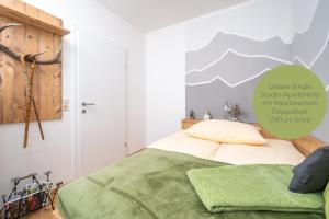 a bedroom with a bed with a green blanket at Zeighaus Murtal in Fohnsdorf