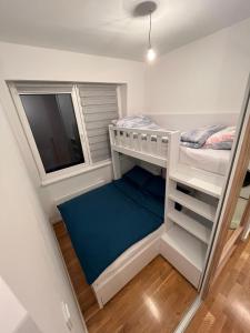 a small bedroom with a bunk bed and a window at Apartman Bjelašnica in Bjelašnica
