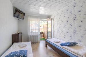 シュチルクにあるPod Wodospademのベッド2台と窓が備わる小さな客室です。