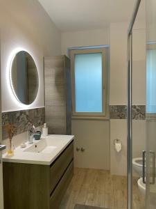 a bathroom with a sink and a mirror and a shower at Casa Cannoni - Delizioso Appartamento Fronte Mare vista Stretto di Messina in Messina