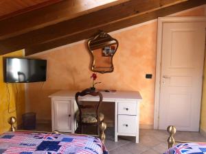 a bedroom with a bed and a desk and a mirror at B&B San Giorgio in Traversetolo