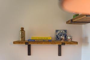 a shelf with books and other items on a wall at Lacton Manor Barns by Bloom Stays in Ashford