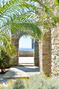 un arco in un muro di mattoni con vista sull'oceano di Andros Homes Sea Side Apartment & Studio a Gavrio